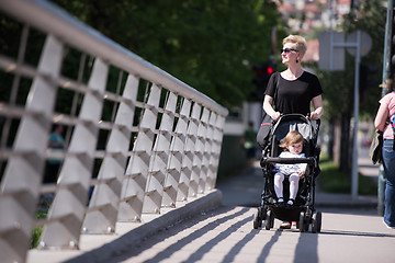 Image showing mother pushed her baby daughter in a stroller