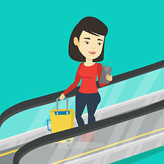 Image showing Woman using smartphone on escalator in airport.