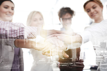 Image showing happy business team with hands on top at office