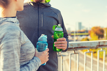 Image showing close up of couple with water bottles outdoors