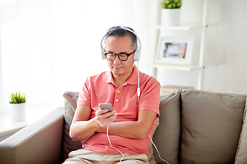 Image showing man with smartphone and headphones at home