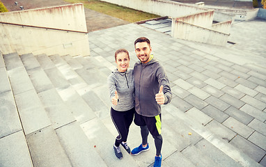 Image showing smiling couple showing thumbs up on city street