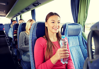 Image showing happy young woman with water bottle in travel bus