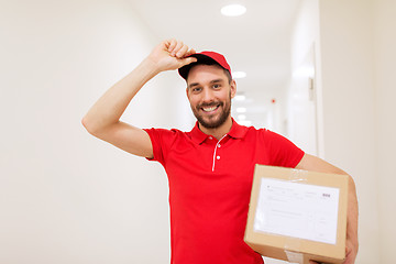 Image showing delivery man with parcel box in corridor