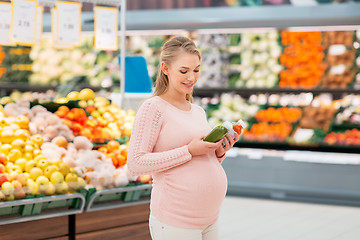 Image showing happy pregnant woman with juice at grocery store