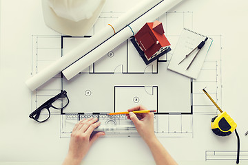 Image showing close up of hands with ruler measuring blueprint