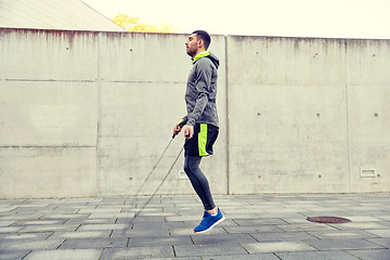 Image showing man exercising with jump-rope outdoors