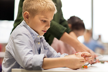 Image showing close up of boy building robot at robotics school