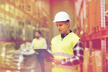 Image showing man with clipboard in safety vest at warehouse