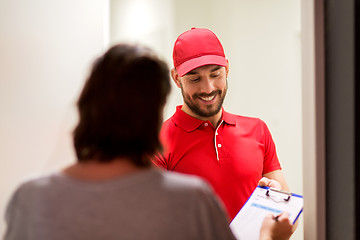 Image showing deliveryman with clipboard at customer home