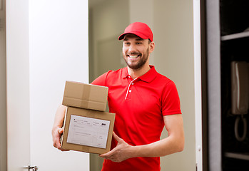 Image showing delivery man with parcel boxes at customer door