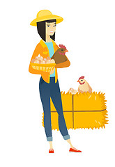 Image showing Farmer holding chicken and basket of eggs.