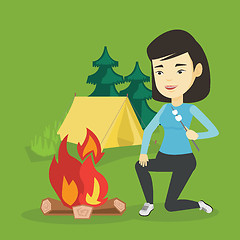 Image showing Woman roasting marshmallow over campfire.