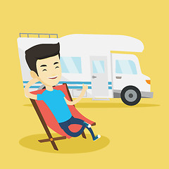 Image showing Man sitting in chair in front of camper van.