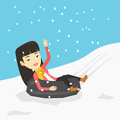 Image showing Woman sledding on snow rubber tube in mountains.