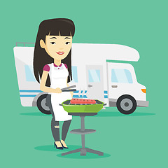 Image showing Woman having barbecue in front of camper van.