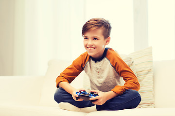 Image showing happy boy with joystick playing video game at home