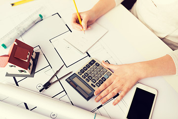 Image showing close up of architect hand counting on calculator