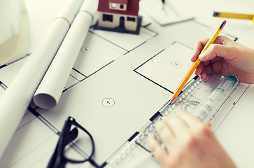 Image showing close up of hands with ruler measuring blueprint