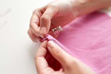 Image showing woman with needle stitching fabric pieces