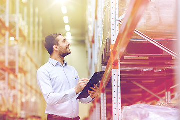 Image showing happy businessman with clipboard at warehouse