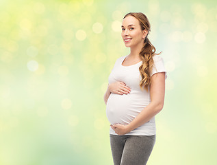 Image showing happy pregnant woman touching her big belly