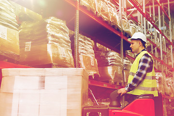 Image showing man on forklift loading cargo at warehouse