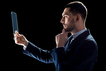 Image showing businessman in suit working with transparent tablet pc