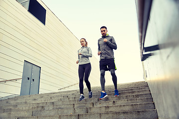 Image showing happy couple running downstairs in city