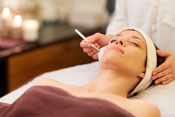 Image showing beautician applying facial mask to woman at spa