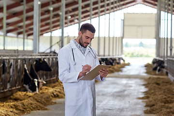 Image showing veterinarian with cows in cowshed on dairy farm