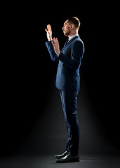 Image showing businessman in suit touching something invisible