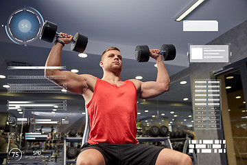 Image showing young man with dumbbells flexing muscles in gym