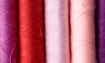 Image showing row of colorful thread spools on table