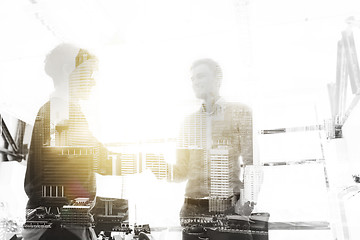 Image showing happy businessmen making handshake at office