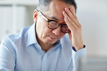 Image showing businessman suffering from headache at office