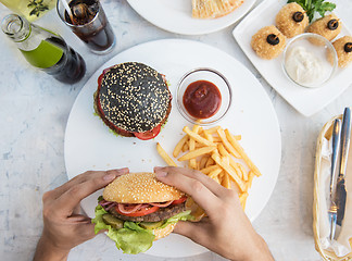 Image showing Man eating burgers