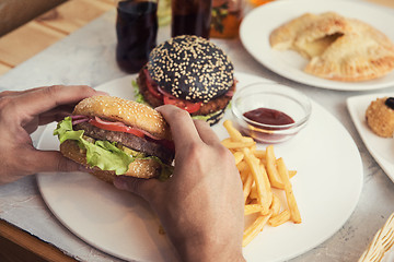 Image showing Man eating burgers