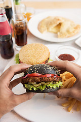 Image showing Man eating burgers