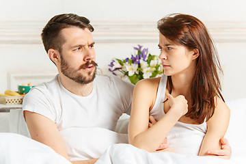 Image showing Young adult heterosexual couple lying on bed in bedroom