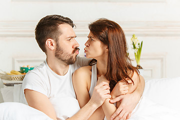 Image showing Young adult heterosexual couple lying on bed in bedroom
