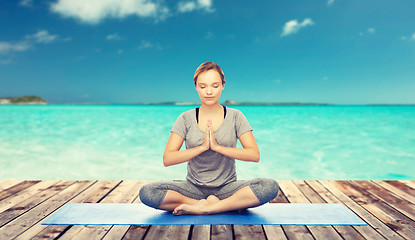 Image showing woman making yoga meditation in lotus pose on mat