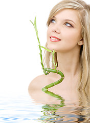 Image showing blue-eyed blonde with bamboo in water