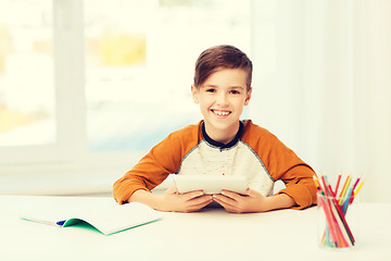 Image showing smiling boy with tablet pc and notebook at home