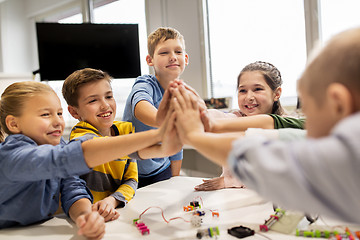 Image showing happy children making high five at robotics school