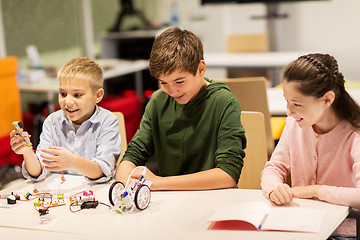 Image showing happy children building robots at robotics school