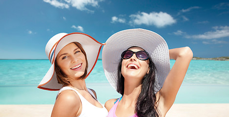 Image showing happy young women in hats on summer beach