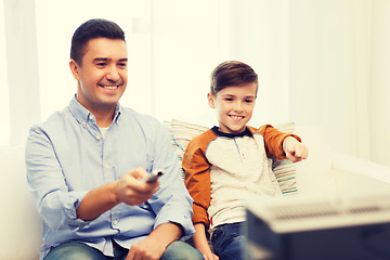 Image showing smiling father and son watching tv at home