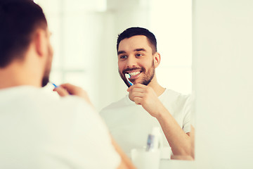 Image showing man with toothbrush cleaning teeth at bathroom