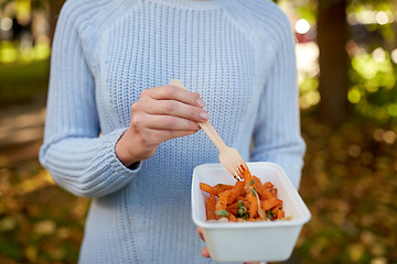 Image showing close up of hand holding plate with sweet potato